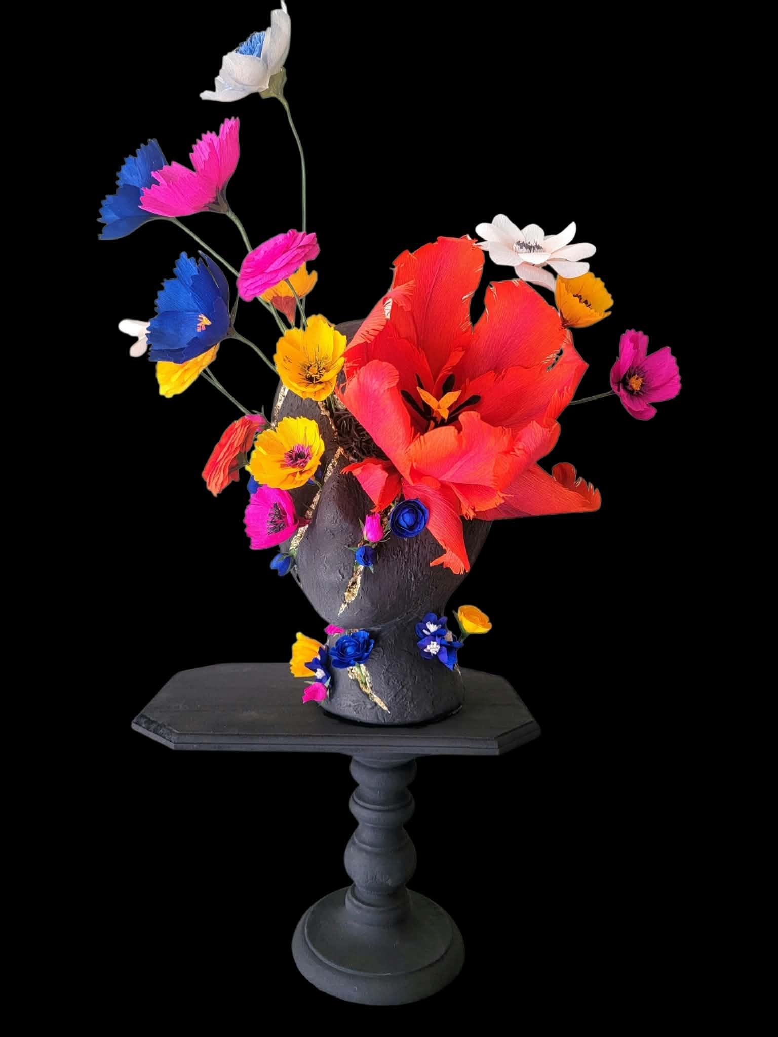 Sculpted head crowned with colourful paper flowers