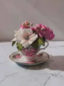A small teacup with anemone, berries, and leaves